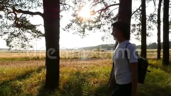 年轻的女游客穿过树林女孩在日落时带着背包旅行a的概念视频的预览图