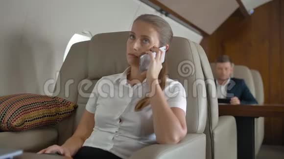 穿着白色西装的女商人谈论商业的私人飞机航班视频的预览图