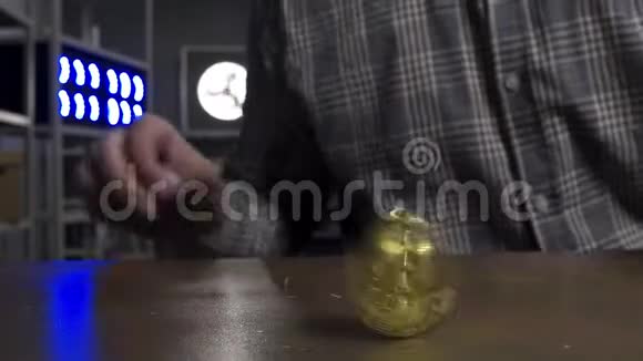 戴着太阳镜的滑稽男子高兴地在棕色桌子上旋转着新的大金比特币硬币视频的预览图