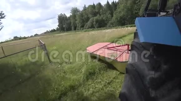 带割草机的拖拉机在有栅栏的树木周围行驶视频的预览图