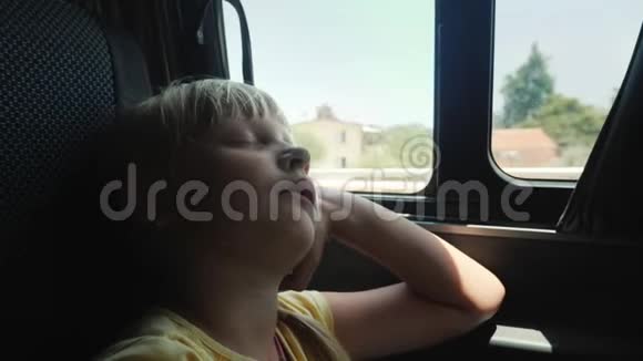 那个女孩正睡在汽车后座的窗边带孩子的繁琐旅程视频的预览图