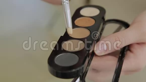 有眼影和化妆刷的调色板女人化妆品早上化妆装饰化妆品带有视频的预览图