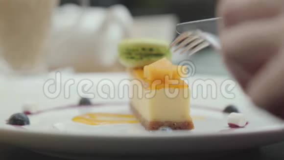 女用手用刀叉切出一块新鲜的土耳其奶油牛奶和坚果蛋糕快关门视频的预览图