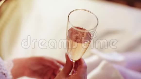 那个女孩拿着一杯香槟快关门在玻璃中可见的气泡视频的预览图