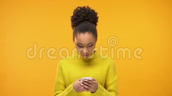 兴奋的非裔美国女士在社交网络上聊天来自心爱的男人的信息视频的预览图