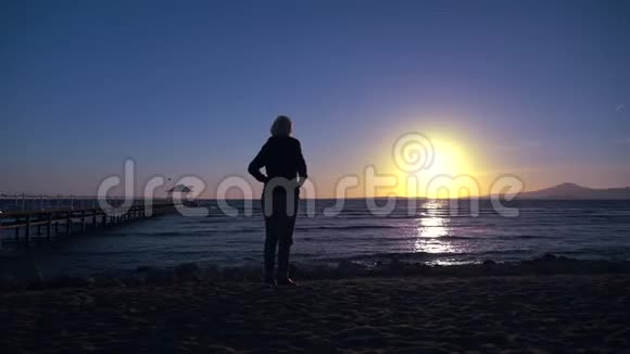 站在海滩上的女人的剪影视频的预览图