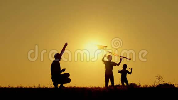 父亲和两个孩子在大自然中玩风筝家庭与户外游憩的统一视频的预览图