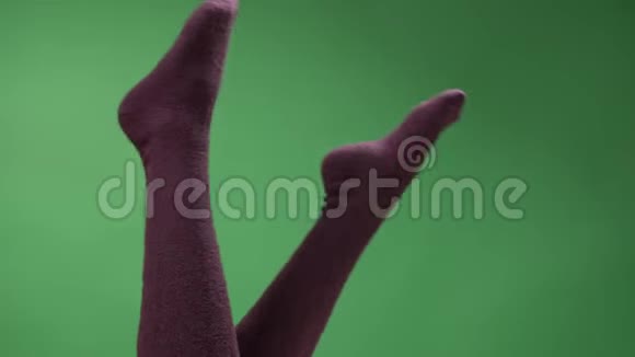 穿着可爱的红膝袜的少女美腿特写高脚拍摄嬉戏地移动背部被隔离在绿色上视频的预览图