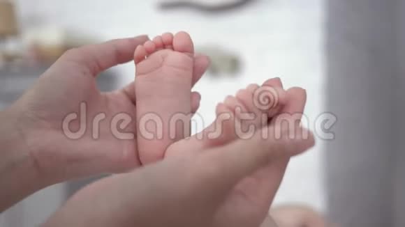 产妇照顾的手抚摸婴儿的小脚视频的预览图