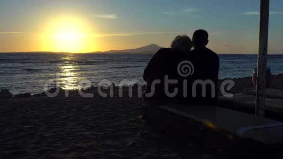 可爱的一对夫妇坐着看海洋日落视频的预览图