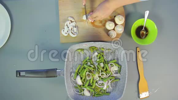 女性手在盘子里切香姜菇视频的预览图