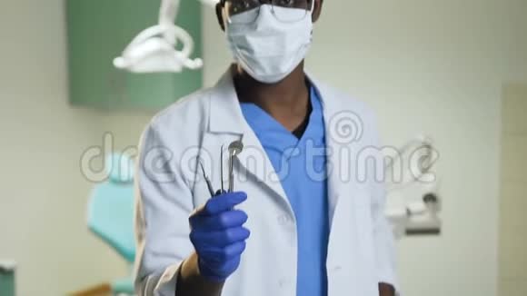 年轻的非洲牙医在牙医办公室带着医疗器械视频的预览图