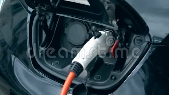 创新电动混合动力汽车充电黑色电动车在车站充电视频的预览图