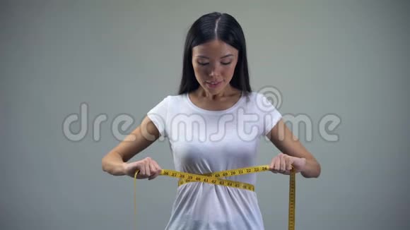 年轻女子收紧测量带用饮食折磨自己暴食症视频的预览图