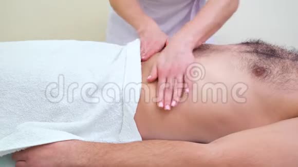 男性病人在治疗室的女性手部按摩胃视频的预览图