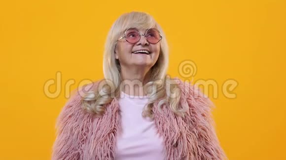 现代女性养老金领取者享受节日下飘落的五颜六色的纸屑乐趣视频的预览图