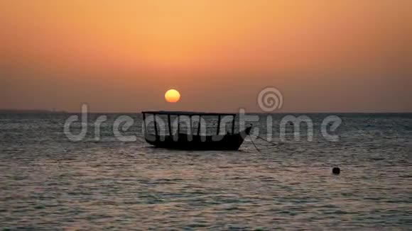 热带非洲海洋日落与大红太阳和渔船剪影视频的预览图
