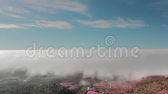 高空超脱美丽的飞行在云层上方的红色火山谷在山路的框架里视频的预览图