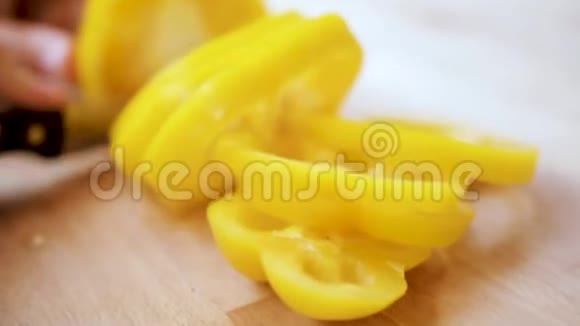 厨房里一只雌性手在家中的砧板上切黄色的辣椒视频的预览图