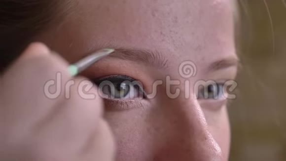 年轻的白种人女化妆师用画笔修饰她的眉毛视频的预览图