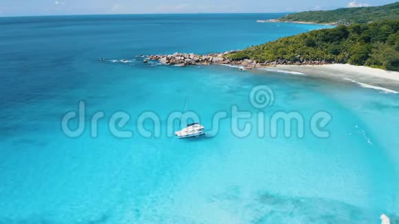 在塞舌尔的空中4k无人机镜头在蓝绿色水上游艇在风景如画的拉迪格热带海岸前视频的预览图