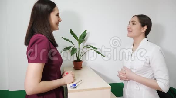 接待友好的护士正在与耐心的年轻妇女交谈侧视视频的预览图