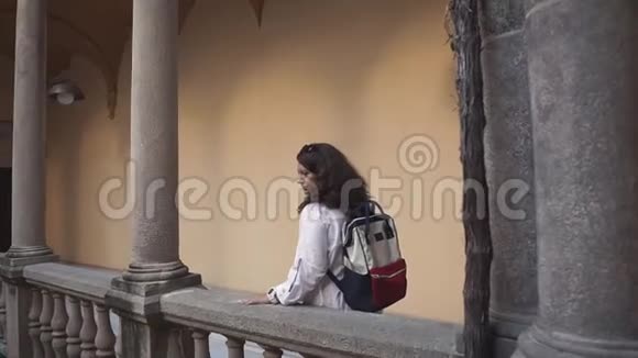 旅行者的女人正在欣赏古老的宫殿建筑走在石头阳台上视频的预览图