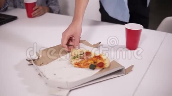 年轻的穿着随意的工作人员在完成任务后重新创造疲惫的同事在现代室内吃披萨视频的预览图