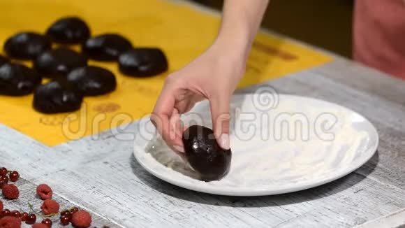 女人的手把巧克力面团放在盘子里糖果师做巧克力层蛋糕视频的预览图