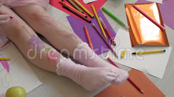 小女孩用毛毡尖笔在脚上画画孩子们创造力发展视频的预览图