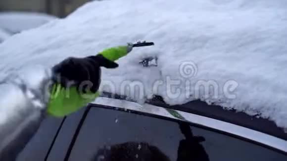 一个人试图清理一辆雪车的屋顶视频的预览图