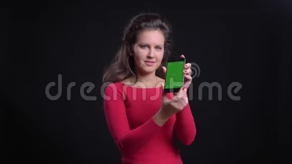 白种人妇女的肖像红色微笑地显示绿色屏幕的平板电脑进入相机在黑色背景视频的预览图