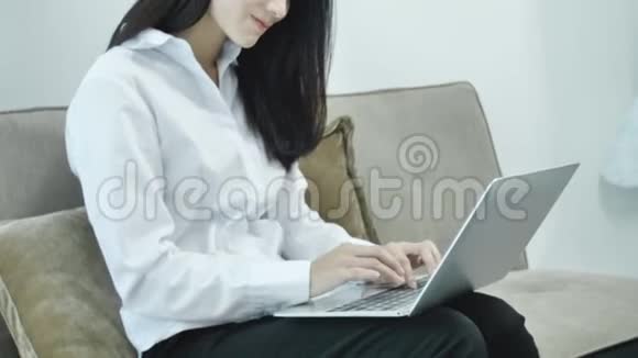 漂亮的少年微笑着在笔记本电脑上打字视频的预览图