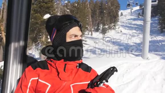手里拿着滑雪杆的人坐在小屋的滑雪电梯里欣赏山景视频的预览图