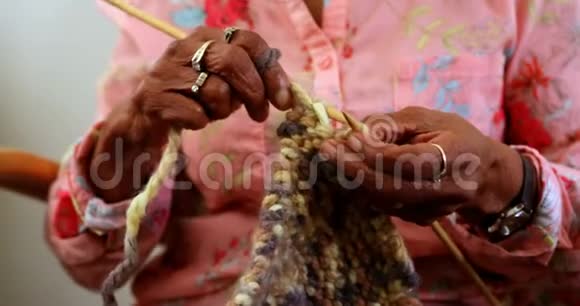 中年妇女在家用纱线编织视频的预览图