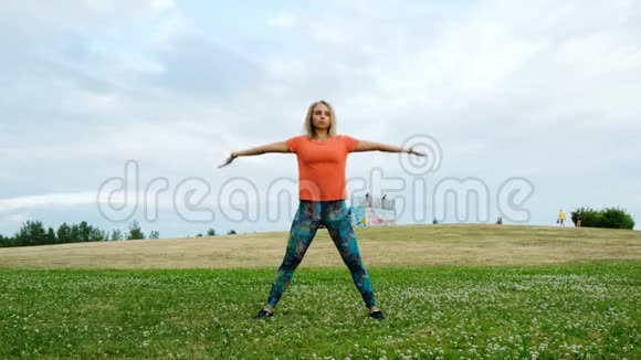 在大自然的城市公园里训练运动的女人一个女孩伸展背部使身体下垂视频的预览图