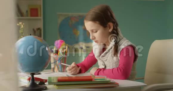 在阳光明媚的日子里小女孩正在家里的桌子上做作业视频的预览图