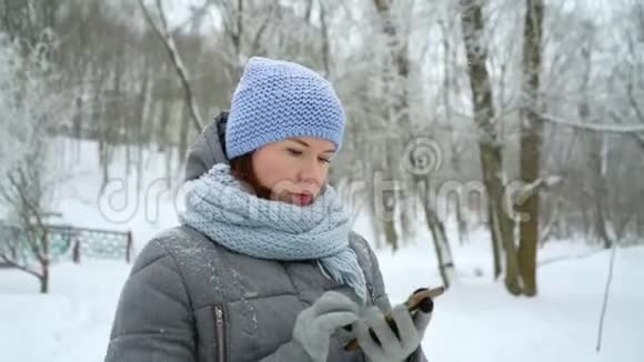 冬季公园的成年女性拨打电话视频的预览图