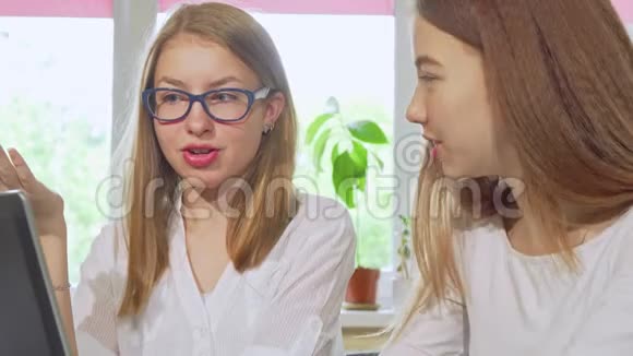 两个十几岁的女孩一起学习在学校用笔记本电脑视频的预览图