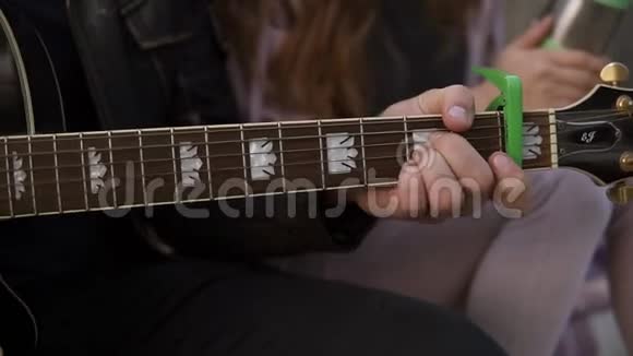 一对夫妇坐在楼梯上一起弹吉他和唱歌穿黑色休闲装的男人坐着弹吉他视频的预览图