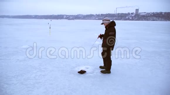 垂钓者用鱼竿给鱼饵做动画冬天钓鱼视频的预览图
