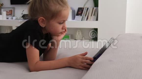 欧洲儿童可爱的小女孩手表或看平板电脑视频的预览图