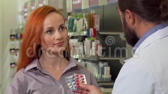 一位美丽的女士从她的药剂师那里得到药丸在药店购物视频的预览图