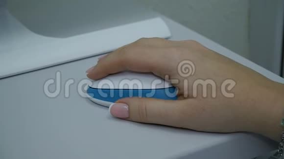 女人拿着白色时髦的老鼠在她的手特写女办公室工作人员正在她身边翻页视频的预览图