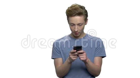 年轻男孩在白色背景下使用智能手机视频的预览图