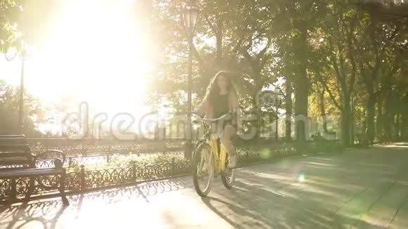 夏天美丽的年轻夫妇骑着自行车在空荡荡的城市公园或林荫大道上停下来坐在长凳上视频的预览图