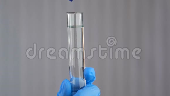 女化验员在试验液中倒入化妆品油身体护理生产香气视频的预览图