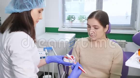 女牙医向病人展示如何用牙刷正确清洁牙齿视频的预览图