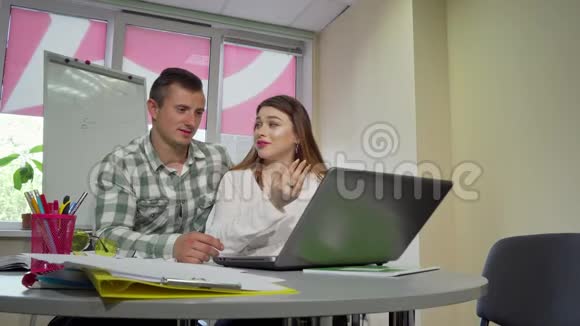 快乐的大学情侣一起学习用笔记本电脑视频的预览图