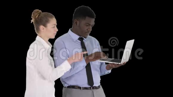 美国黑人商业顾问在笔记本电脑屏幕上显示一些东西与白人女商人交谈阿尔法频道视频的预览图